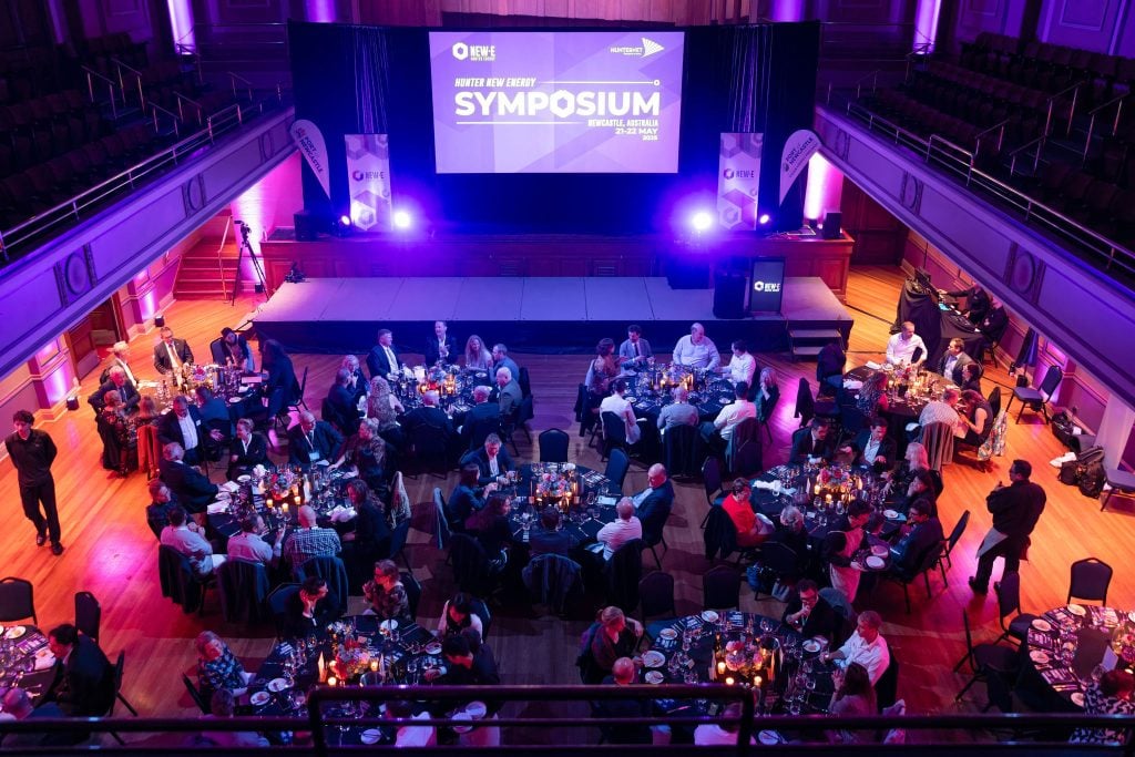 wide shot looking down upon a large formal dinner or gala taking place in a grand hall