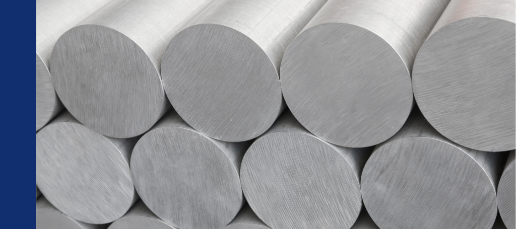 A neat stack of metallic, cylindrical bars or billets, likely aluminum or steel alloy.
